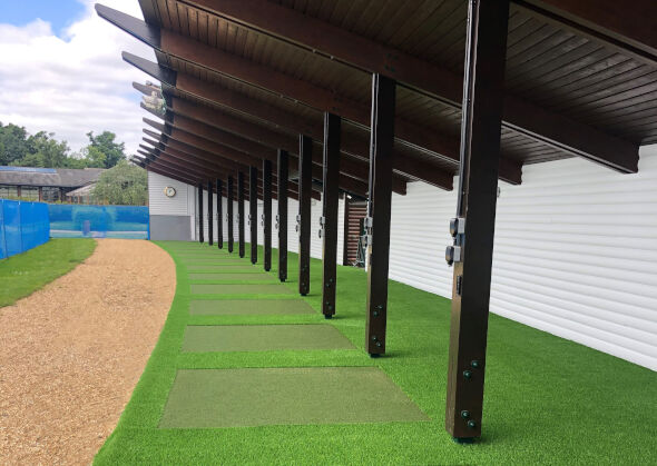 Jacksonville Covered outdoor tee line with light green synthetic grass boxes inside a dark green synthetic grass strip