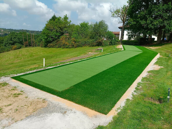Jacksonville Outdoor tee line consisting of one continuous green synthetic grass strip surrounded by trees