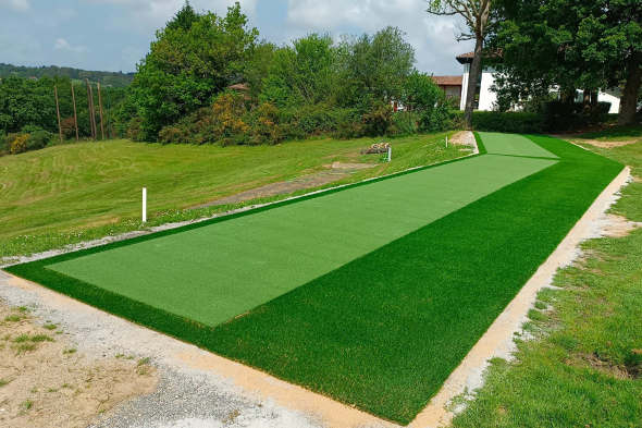 Jacksonville Outdoor tee line consisting of one continuous green synthetic grass strip surrounded by trees